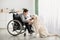 Happy impaired teenager playing with his dog at home, full length portrait. Animal human friendship concept