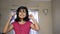 Happy Indian asian caucasian girl wearing headphone enjoying listening music on mobile nodding, dancing and singing song portrait