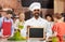 Happy indian chef with chalkboard at cooking class