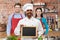 Happy indian chef with chalkboard at cooking class