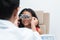 Happy Indian child girl doing examine eyesight with trial frame and lens with ophthalmologist or optometrist for eyes test