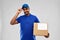 Happy indian delivery man with parcel box in blue