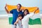 Happy Indian family holding national tricolour flag on beach Goa