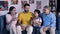 A happy Indian family watching television together while relaxing together on the sofa