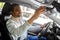 happy indian man or driver adjusting mirror in car