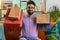 Happy indian man shopaholic consumer came back home after online shopping sale with bags at home