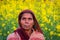 Happy Indian old woman standing in mustard field.