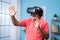 Happy indian senior man with VR or virtual reality headset experiencing metaverse at home - concept of imagination