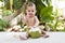 Happy infant and joyful baby in travel. Eats and drinks green young coconut