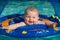 Happy infant playing in pool while sitting in baby float