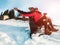 Happy influencers couple having fun with wood vintage sledding on snow high mountains - Young crazy people enoying winter vacation