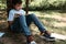 Happy inspired smart primary school student boy in casual denim, reading a book in the park. Kids. Erudition. Lifestyle
