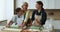 Happy intergenerational women gather together in kitchen to prepare cookies