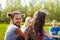 Happy international teens sit together on meadow