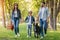 Happy interracial family with picnic basket walking with dog in forest