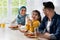 Happy islamic family with little daughter eating tasty breakfast together in kitchen