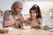 Happy islamic mom and her cute daughter preparing dough in kitchen together