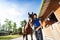 Happy jockey girl hugging her purebred bay horse