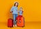 Happy journey! family of travelers mother and child  with suitcases tickets and passports on yellow background