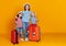 Happy journey! family of travelers mother and children with suitcases tickets and passports on yellow background