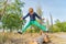 Happy and joyful boy jumps up legs apart in the park