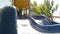 Happy joyful kid sliding down a blue slide on a playground in park