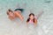 Happy joyful kids relaxing near the beach in shallow ocean turquoise water and enjoying their time