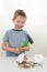 Happy, joyful, laughing preschooler smashed his piggy bank with a hammer. Vertical photo. The idea is that the child has
