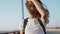 Happy joyful smiling young pretty woman in white t-shirt is standing on the bridge on blue sky background, laughing