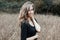 Happy joyful stylish modern young woman model with beautiful smile in fashionable black t-shirt posing on a corn field