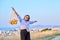 Happy joyful woman with raised hands with grid of oranges, blue sky background