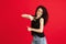 Happy, joyful young Caucasian woman posing isolated on red background.