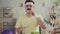 Happy and joyful young sporty man with a mustache eating vegetables sitting at the table