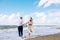 Happy just married middle age couple walk at beach against blue sky with clouns and have fun on summer day.