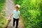 Happy kid in blooming nature. Little boy child in green forest. Small child with toy in shopping bag. summer. Childhood