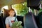 Happy kid boy sitting in car during family journey and trip. Positive child enjoying vacations by car. Summertime