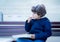 Happy kid enjoying eating potato chips for sunday lunch, Cute boy eating french fries. Child siting on bench having picnic outdoor