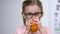Happy kid in eyeglasses drinking carrot juice closeup, strong vision, vitamin A