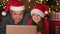 Happy kid girl and father laugh while watching funny Christmas movie on laptop