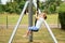 Happy kid girl rids on zip line swing outdoor game play equipment on playground. Child having fun outdoors. Preschool