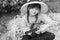 Happy kid girl in straw hat with ukulele having fun on summer field.