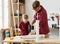 Happy kid helping father in carpentry studio