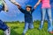 Happy kid holding parents hands in park