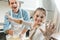happy kid looking at camera and showing hands in flour in front of mixing dough father