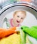 Happy kid looking inside wash machine with clothes