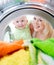 Happy kid and mother looking inside wash machine with interest