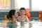 Happy kid and mother in swimming pool