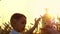 Happy kid playing with a small wooden windmill at sunset. Wheat field. The concept of agriculture and harvesting.