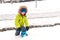 Happy kid plays with snow. Little boy in fashion winter outfit outdoors. Family winter vacation