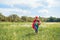 happy kid in red superhero cape and mask running in meadow